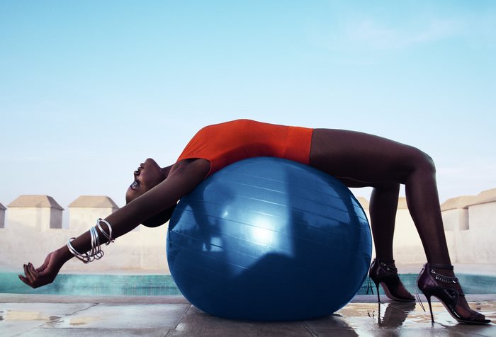 Lupita Nyongo on a blue exercise ball