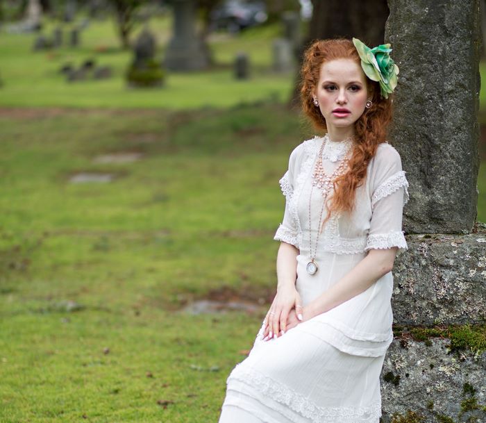 Madelaine Petsch in a white dress in a graveyard