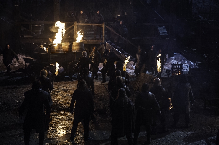 Owen Teale and group with torches in a dark setting