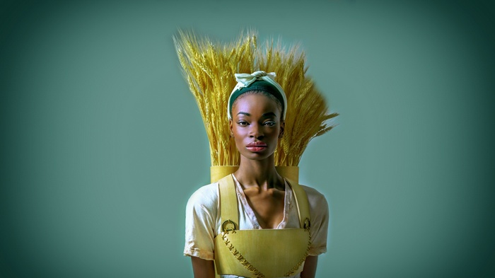 Woman with wheat stalks on her back