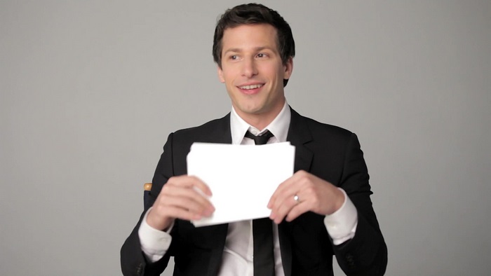 Andy Samberg holding papers