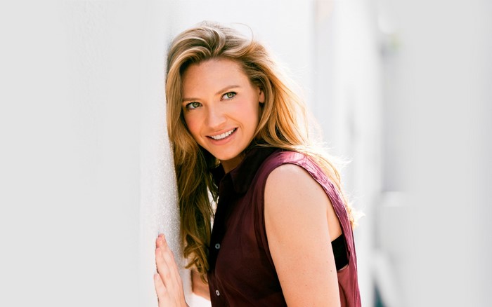 Anna Torv leaning against a white wall