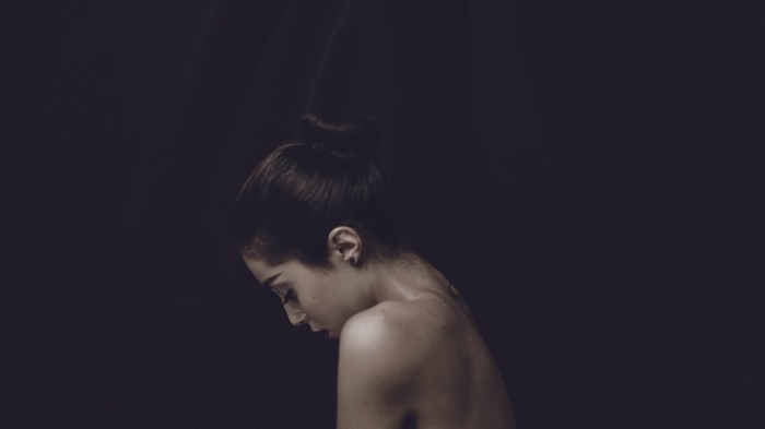 Woman with hair in a bun looking down