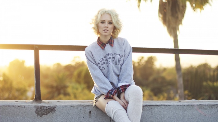 Woman sitting on a ledge at sunset