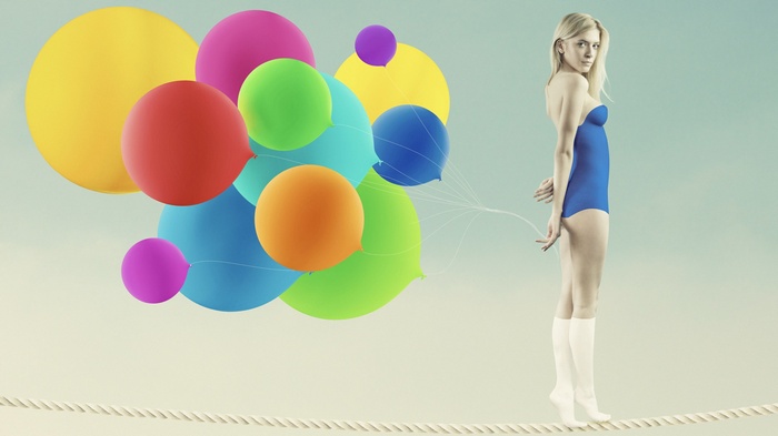 Woman on tightrope with balloons