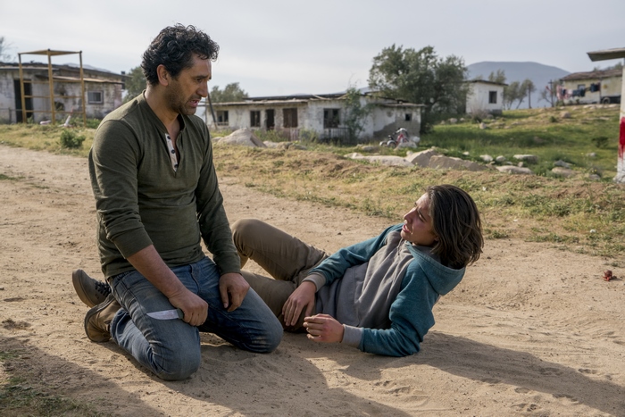 Cliff Curtis and a young person in a rural setting