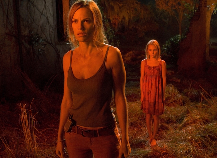 Hilary Swank and a young girl in a dark forest