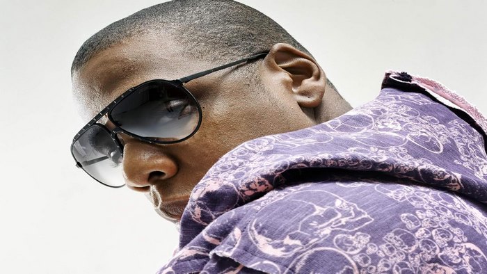 Jay-Z wearing sunglasses and a purple patterned shirt