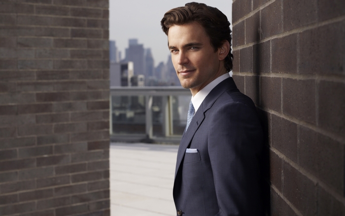 Matt Bomer leaning against a brick wall