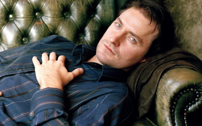 Richard Armitage lying on a leather couch