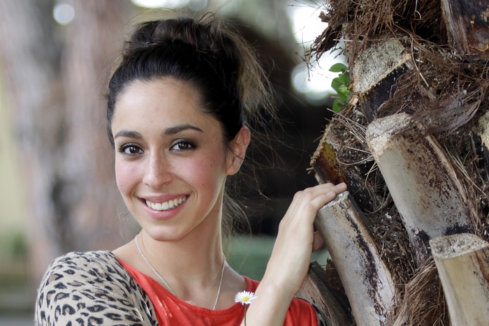 Oona Chaplin posing by a palm tree