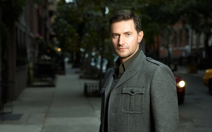 Richard Armitage in a grey coat on a street
