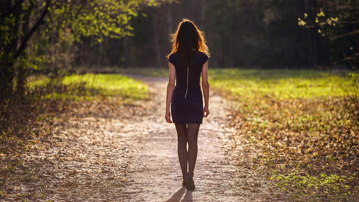 Woman walking on a path in a forest