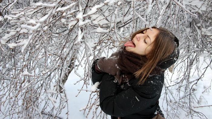 Girl sticking tongue out at icy branches