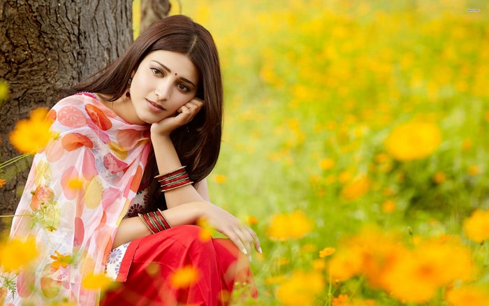 Shruti Haasan sitting in a field of yellow flowers