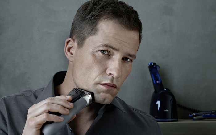 Til Schweiger shaving with electric razor