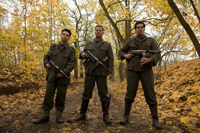 Three soldiers with submachine guns in a forest