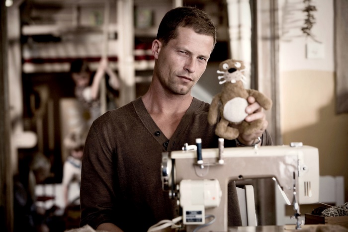 Til Schweiger with a stuffed animal and sewing machine