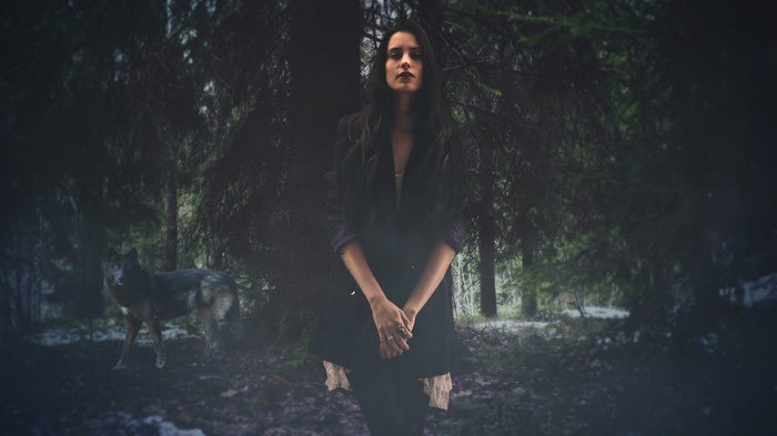 Woman and wolf in a dark forest