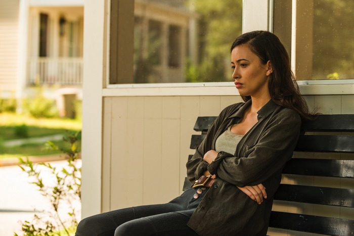 Christian Serratos sitting on a bench