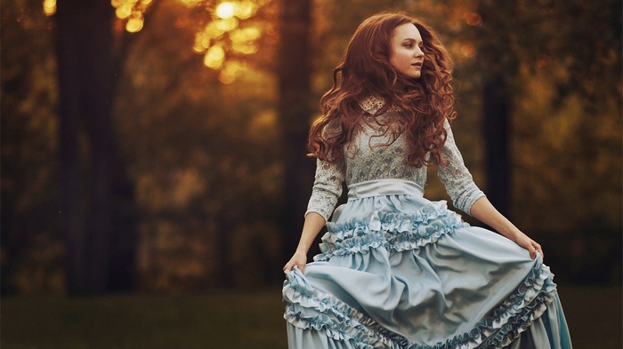 Woman in a blue ruffled dress in a park