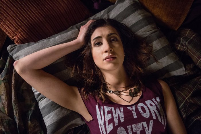 Dana DeLorenzo lying on a bed