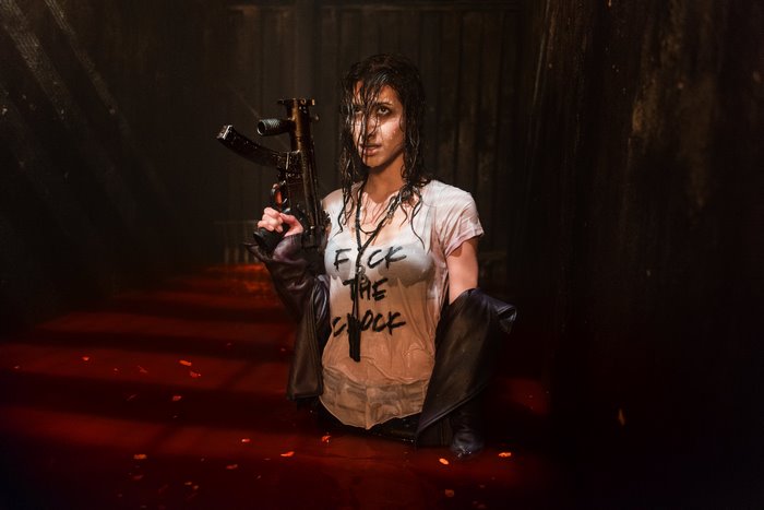 Dana DeLorenzo holding a gun in red liquid