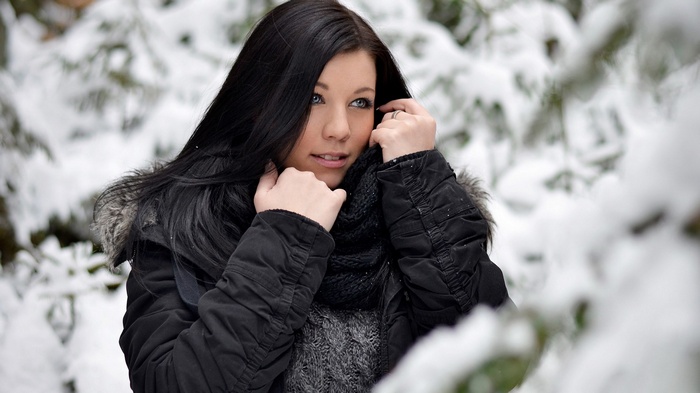 Woman in winter coat in snowy forest