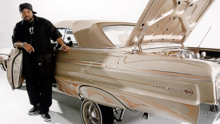 Ice Cube posing with a custom Chevrolet Impala convertible