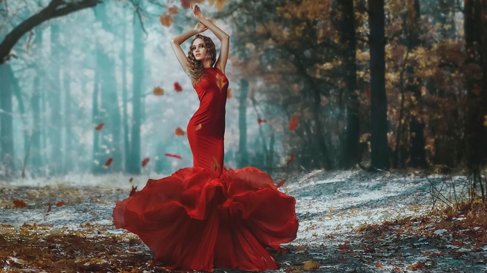 Woman in red dress in autumn forest
