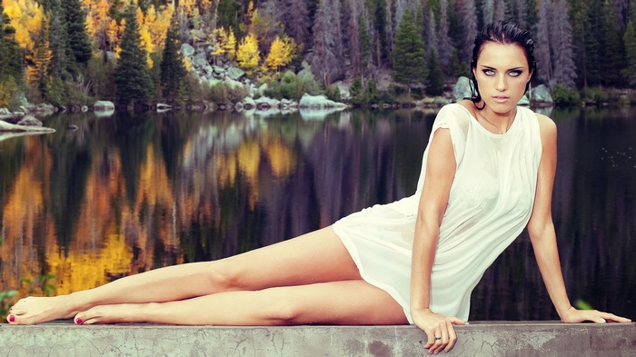Woman in wet white dress by lake