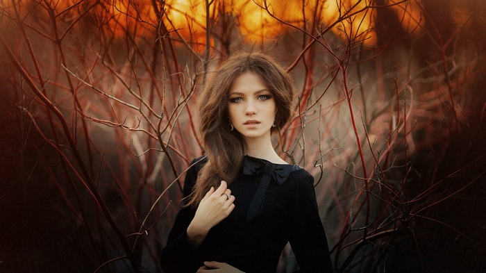 Woman in black dress among branches