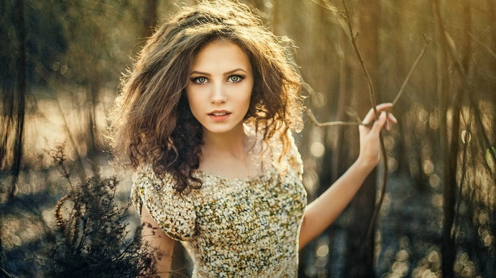 Woman with curly hair in a forest