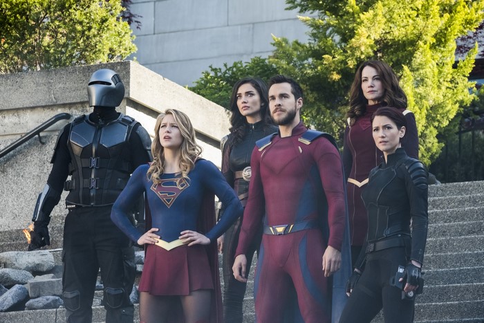 Supergirl and allies standing on stairs