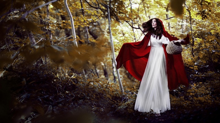 Woman in red cloak and white dress in forest