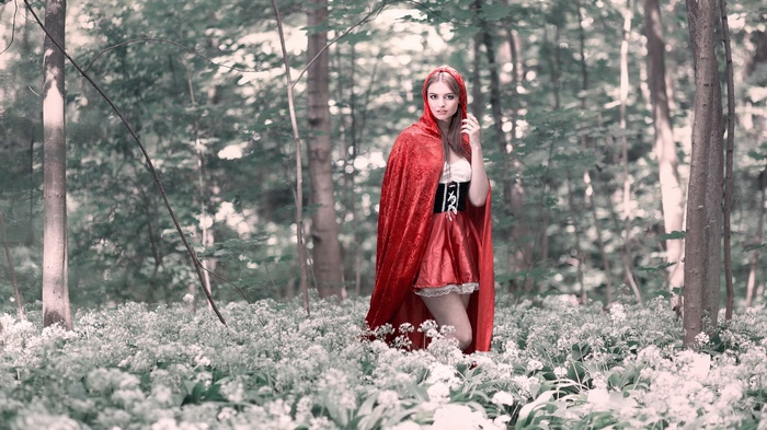 Woman in red cloak in a forest