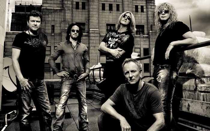 Def Leppard band members on a rooftop