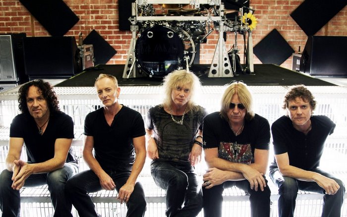 Def Leppard band members posing in a studio
