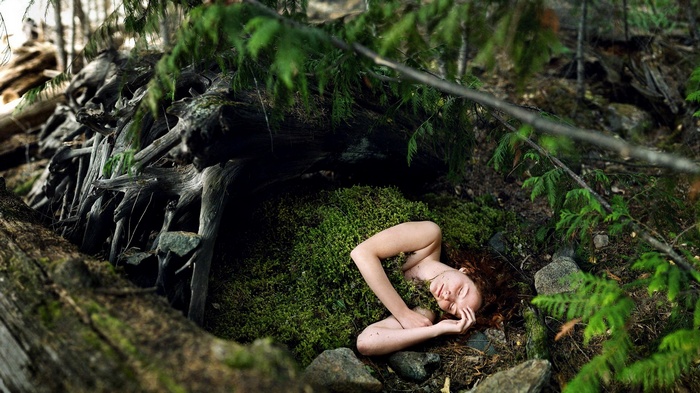 Woman lying on moss in a forest