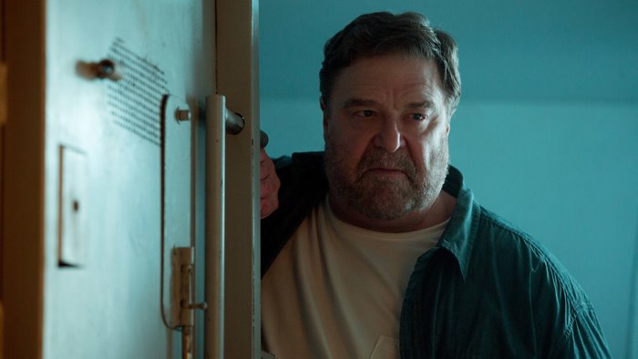 John Goodman in a dimly lit room