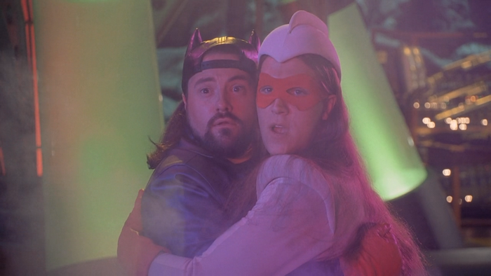 Kevin Smith and woman in superhero costumes