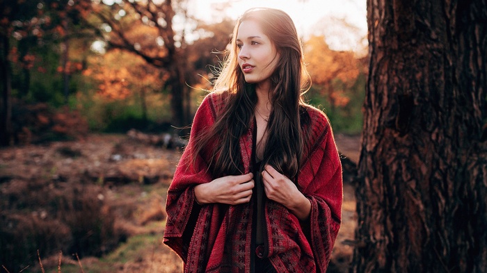 Woman in red shawl in autumn forest