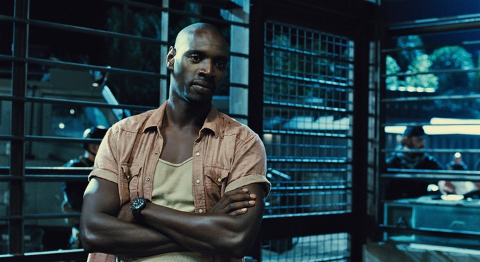 Omar Sy in a dimly lit room