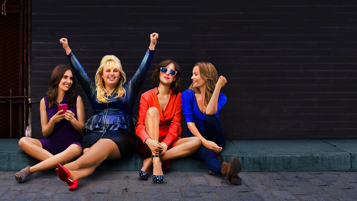 Rebel Wilson and friends sitting on a curb
