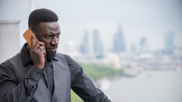 Omar Sy on the phone with London skyline