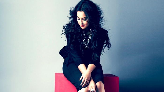 Sonakshi Sinha sitting on a red cube