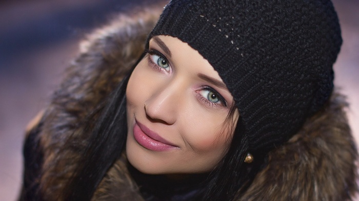 Woman wearing a black beanie and fur coat