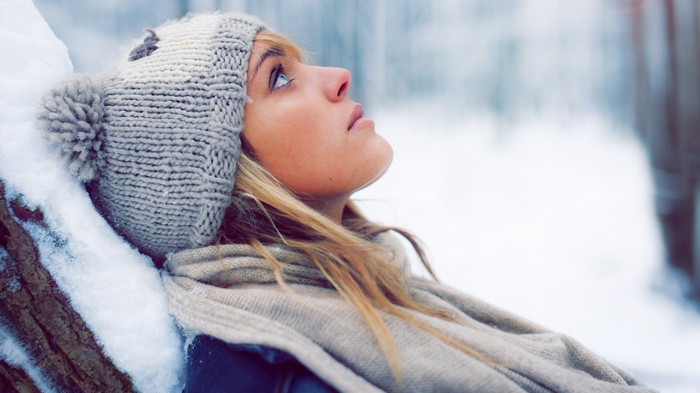 Woman in winter hat and scarf looking up