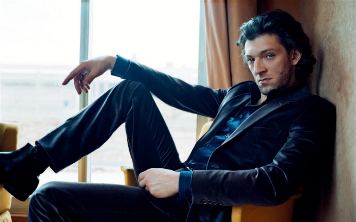 Vincent Cassel sitting in a chair