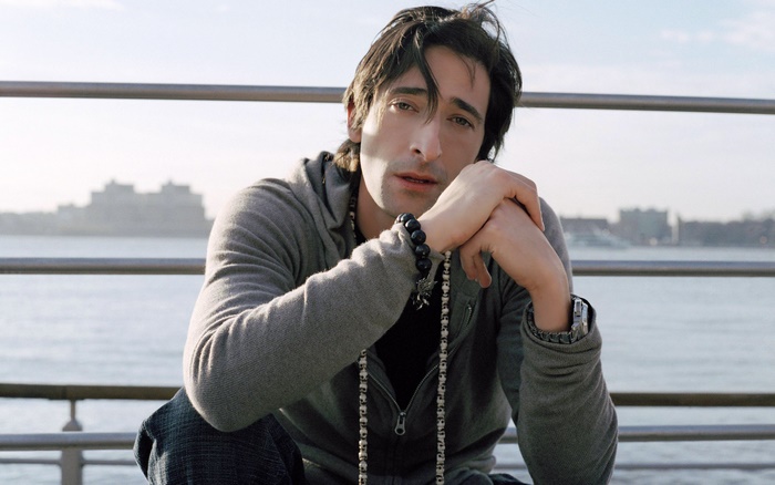 Adrien Brody sitting by the water